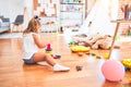 Young beautiful blonde girl kid enjoying play school with toys at kindergarten, smiling happy playing with inteligence toys at