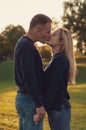 Young beautiful blonde girl kisses her boyfriend. Family look. Kiss of love of two partners Royalty Free Stock Photo