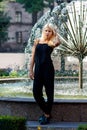 Young beautiful blonde girl posing on the background of the urban landscape. lady in a black dress with a pleasant appearance Royalty Free Stock Photo