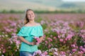 Young beautiful blonde girl on a rose plantation .