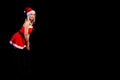 Young beautiful blonde girl in a sexy red Snow Maiden costume or Santa Claus on a black isolated background in the Christmas and Royalty Free Stock Photo