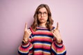 Young beautiful blonde girl wearing glasses and casual sweater over pink isolated background Pointing up looking sad and upset, Royalty Free Stock Photo