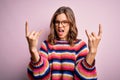 Young beautiful blonde girl wearing glasses and casual sweater over pink isolated background shouting with crazy expression doing Royalty Free Stock Photo