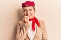 Young beautiful blonde girl wearing stewardess uniform looking stressed and nervous with hands on mouth biting nails