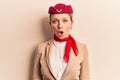 Young beautiful blonde girl wearing stewardess uniform scared and amazed with open mouth for surprise, disbelief face