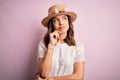 Young beautiful blonde girl wearing summer hat over pink isolated background with hand on chin thinking about question, pensive Royalty Free Stock Photo