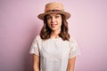 Young beautiful blonde girl wearing summer hat over pink isolated background with a happy and cool smile on face Royalty Free Stock Photo