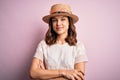 Young beautiful blonde girl wearing summer hat over pink isolated background happy face smiling with crossed arms looking at the Royalty Free Stock Photo