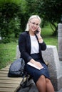 Young beautiful blonde in glasses talking on a smartphone and laughing. Business woman on the street with a phone in her Royalty Free Stock Photo