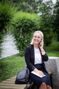 Young beautiful blonde in glasses talking on a smartphone and laughing. Business woman on the street with a phone in her Royalty Free Stock Photo