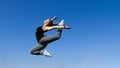 Young beautiful blonde hair sport girl jumping on blue sky background Royalty Free Stock Photo