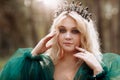 Young beautiful blonde hair woman queen. Princess walks. autumn green forest mystic. Vintage medieval shiny crown. Long evening Royalty Free Stock Photo
