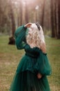 Young beautiful blonde hair woman queen. Princess walks. autumn green forest mystic. Vintage medieval shiny crown. Long evening Royalty Free Stock Photo