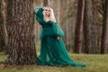 Young beautiful blonde hair woman queen. Princess walks. autumn green forest mystic. Vintage medieval shiny crown. Long evening Royalty Free Stock Photo