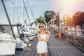 Young beautiful woman staying near yachts in harbor Royalty Free Stock Photo