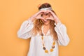 Young beautiful blonde hippie woman with blue eyes wearing sunglasses and accessories Doing heart shape with hand and fingers