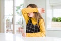 Young beautiful blonde kid girl wearing casual yellow sweater at home covering eyes with arm, looking serious and sad Royalty Free Stock Photo