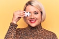 Young beautiful blonde plus size woman holding one piece of puzzle over eye looking positive and happy standing and smiling with a Royalty Free Stock Photo