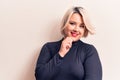 Young beautiful blonde plus size woman wearing casual sweater over isolated white background smiling looking confident at the Royalty Free Stock Photo