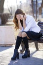 Young beautiful blonde schoolgirl sitting on a bench Royalty Free Stock Photo