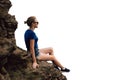 Young beautiful blonde tourist girl sits on a rocky ledge of a rock and looks far into the distance in the early foggy morning. Royalty Free Stock Photo