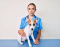 Young beautiful blonde veterinarian woman checking dog health thinking attitude and sober expression looking self confident Royalty Free Stock Photo