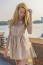 Young beautiful blonde woman in a beautiful dress in a summer park