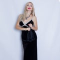 Young beautiful blonde woman in black evening dress.