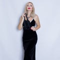 Young beautiful blonde woman in black evening dress.