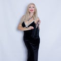 Young beautiful blonde woman in black evening dress.