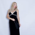 Young beautiful blonde woman in black evening dress.
