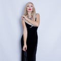 Young beautiful blonde woman in black evening dress.