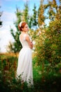 Young beautiful blonde woman in blooming garden. Bride. Royalty Free Stock Photo