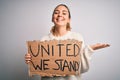 Young beautiful blonde woman with blue eyes asking for united stand holding banner very happy and excited, winner expression