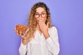 Young beautiful blonde woman with blue eyes holding bowl with healthy almond snack cover mouth with hand shocked with shame for