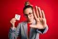 Young beautiful blonde woman with blue eyes holding reminder paper with question mark with open hand doing stop sign with serious Royalty Free Stock Photo