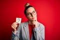 Young beautiful blonde woman with blue eyes holding reminder paper with question mark serious face thinking about question, very Royalty Free Stock Photo