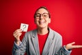 Young beautiful blonde woman with blue eyes holding reminder paper with question mark very happy and excited, winner expression Royalty Free Stock Photo