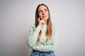 Young beautiful blonde woman with blue eyes standing over isolated background with hand on chin thinking about question, pensive Royalty Free Stock Photo