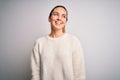 Young beautiful blonde woman with blue eyes wearing casual sweater over white background looking away to side with smile on face, Royalty Free Stock Photo