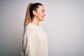 Young beautiful blonde woman with blue eyes wearing casual sweater over white background looking to side, relax profile pose with Royalty Free Stock Photo