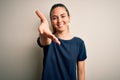 Young beautiful blonde woman with blue eyes wearing casual t-shirt over white background smiling friendly offering handshake as Royalty Free Stock Photo