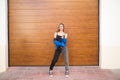 young and beautiful blonde woman dressed in black t-shirt and blue leather jacket and jeans on wooden background poses for photos Royalty Free Stock Photo