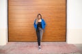 young and beautiful blonde woman dressed in black t-shirt and blue leather jacket and jeans on wooden background poses for photos Royalty Free Stock Photo