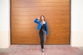 young and beautiful blonde woman dressed in black t-shirt and blue leather jacket and jeans on wooden background poses for photos Royalty Free Stock Photo