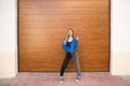 young and beautiful blonde woman dressed in black t-shirt and blue leather jacket and jeans on wooden background poses for photos Royalty Free Stock Photo