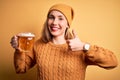 Young beautiful blonde woman drinking jar of beer standing over isolated yellow background happy with big smile doing ok sign, Royalty Free Stock Photo