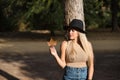 Young, beautiful, blonde woman with green eyes and hat, holding a dry leaf in her hand with melancholic look. Concept looks,