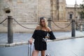 Young and beautiful blonde woman with her suitcase under her arm ready and waiting to start her holiday. Holiday and travel Royalty Free Stock Photo