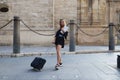 Young and beautiful blonde woman with her suitcase under her arm ready and waiting to start her holiday. Holiday and travel Royalty Free Stock Photo